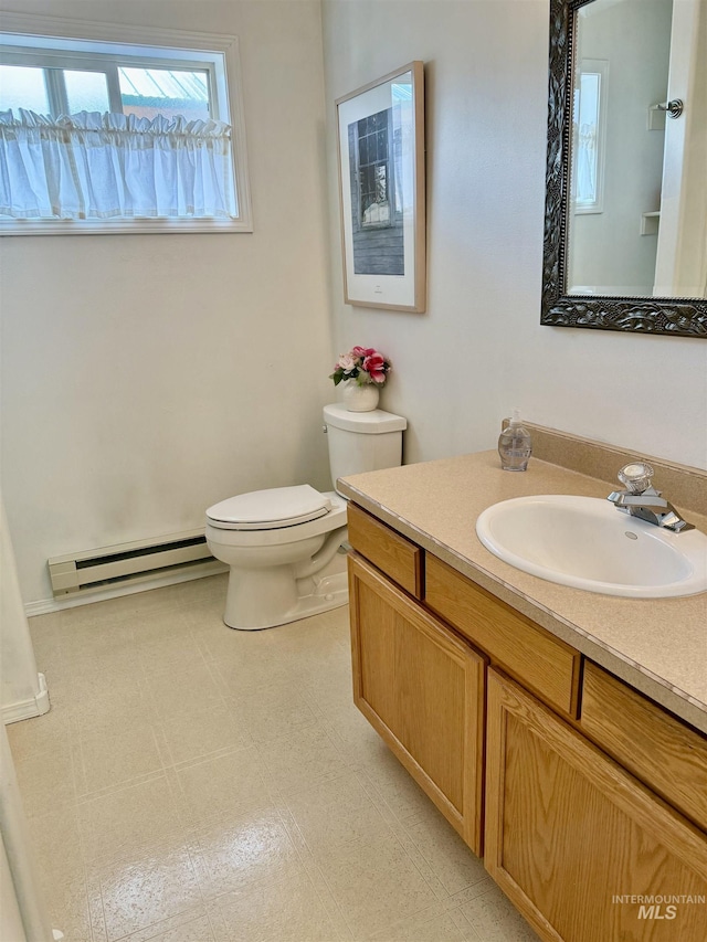 1425 Clements, Mccall, ID 83638 - half bathroom with a baseboard heating unit, plenty of natural light, toilet, and vanity