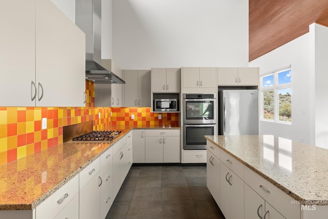 4336 N Star Vista Ln, Eagle, ID 83616 - kitchen featuring appliances with stainless steel finishes, wall chimney exhaust hood, backsplash, and light stone countertops