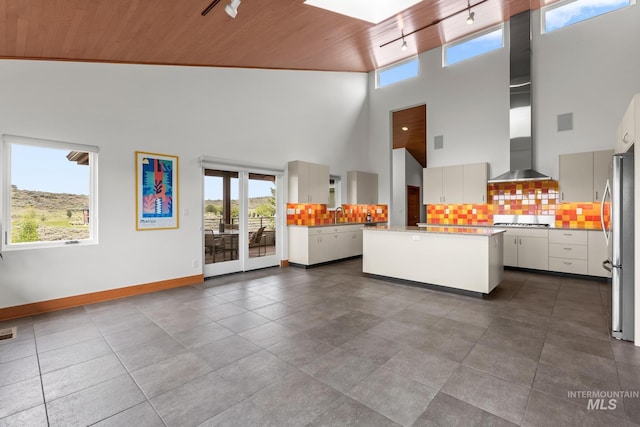 4336 N Star Vista Ln, Eagle, ID 83616 - unfurnished living room with rail lighting, wooden ceiling, a towering ceiling, baseboards, and a sink