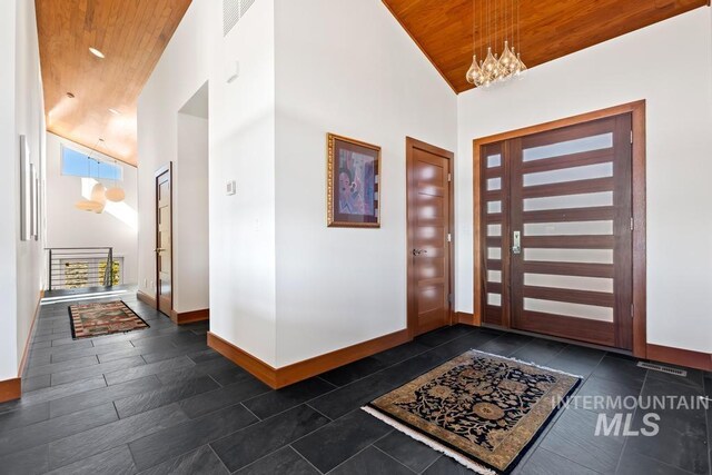4336 N Star Vista Ln, Eagle, ID 83616 - entryway with high vaulted ceiling, wood ceiling, baseboards, a chandelier, and dark tile patterned floors