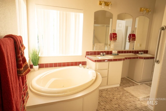 bathroom featuring tile patterned flooring, dual bowl vanity, and a tub to relax in