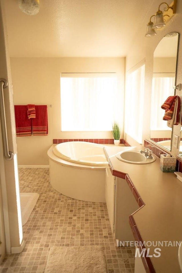 bathroom featuring tile patterned floors, a healthy amount of sunlight, vanity, and a bath