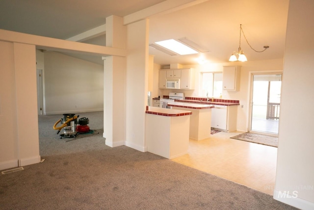 kitchen featuring a center island, vaulted ceiling, white cabinetry, and light colored carpet