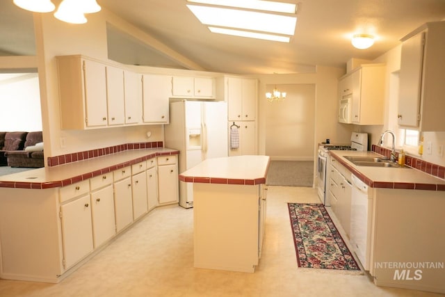 kitchen featuring tile countertops, sink, a center island, light tile patterned flooring, and white appliances