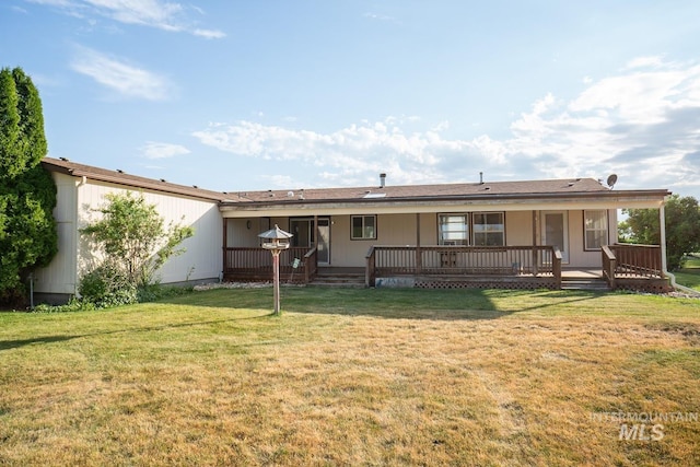 rear view of house featuring a deck and a yard