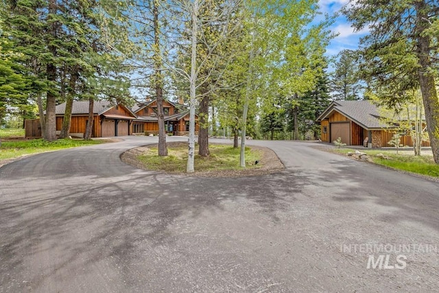 1418 Club Hill Blvd, Mccall, ID 83638 - view of front facade featuring curved driveway, an attached garage, and board and batten siding