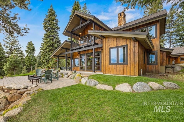 1418 Club Hill Blvd, Mccall, ID 83638 - back of house with a balcony, a chimney, a fire pit, a lawn, and a patio