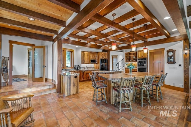 1418 Club Hill Blvd, Mccall, ID 83638 - kitchen with baseboards, appliances with stainless steel finishes, brown cabinets, a kitchen island, and beam ceiling