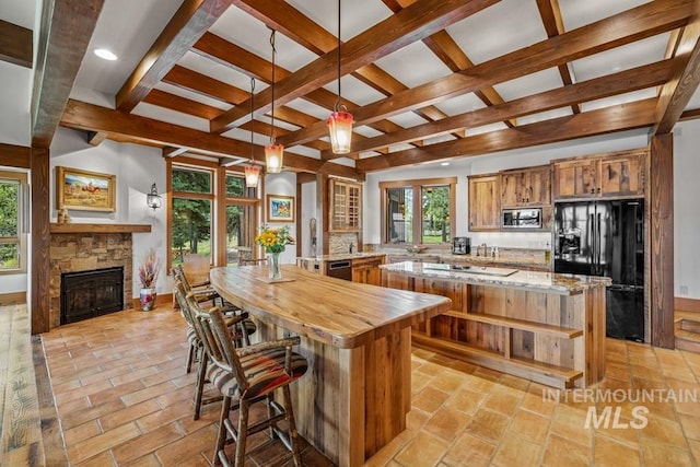 1418 Club Hill Blvd, Mccall, ID 83638 - kitchen with black refrigerator with ice dispenser, stainless steel microwave, a center island, coffered ceiling, and a fireplace