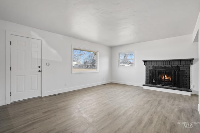 923 13th St S, Nampa, ID 83651 - unfurnished living room with wood finished floors, baseboards, and a fireplace