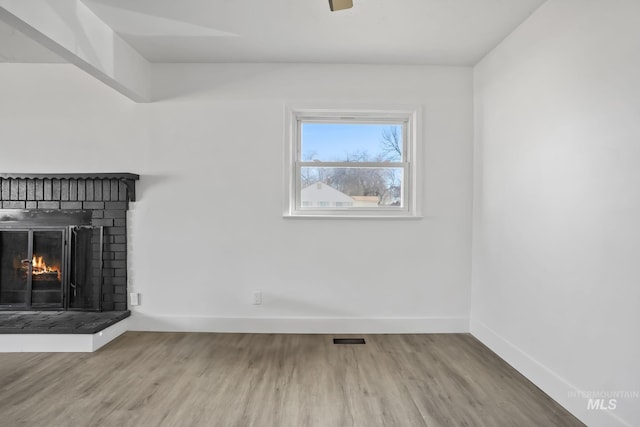 923 13th St S, Nampa, ID 83651 - unfurnished living room featuring baseboards, wood finished floors, and a fireplace