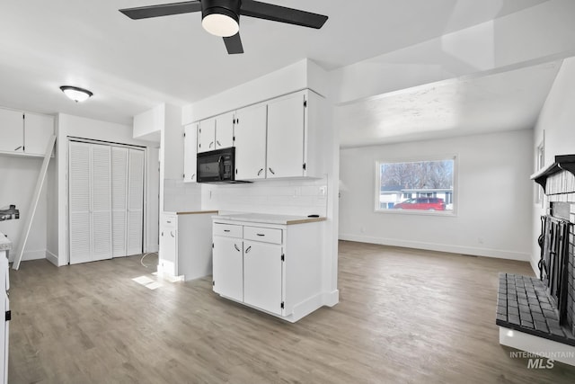 923 13th St S, Nampa, ID 83651 - kitchen with ceiling fan, light wood-style flooring, white cabinets, light countertops, and black microwave