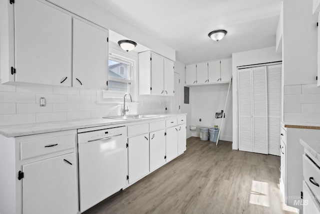 923 13th St S, Nampa, ID 83651 - kitchen featuring white dishwasher, a sink, white cabinetry, light wood finished floors, and tasteful backsplash