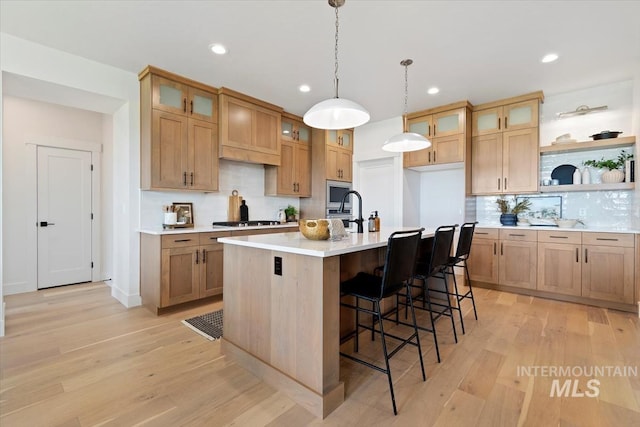 kitchen with open shelves, light wood finished floors, stainless steel gas stovetop, and light countertops