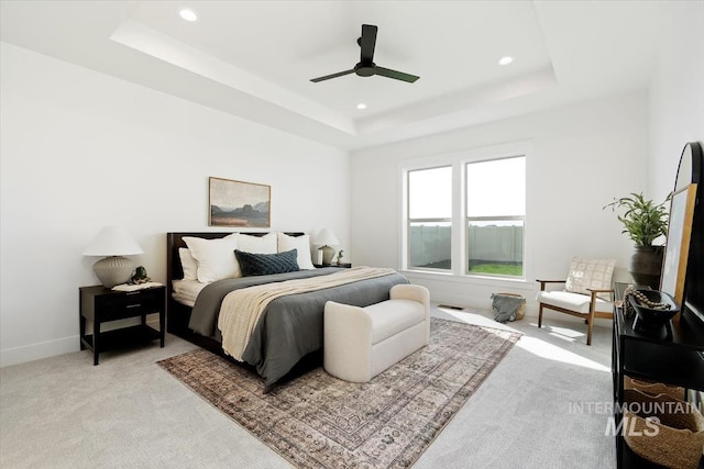 bedroom featuring a tray ceiling, light carpet, baseboards, and recessed lighting