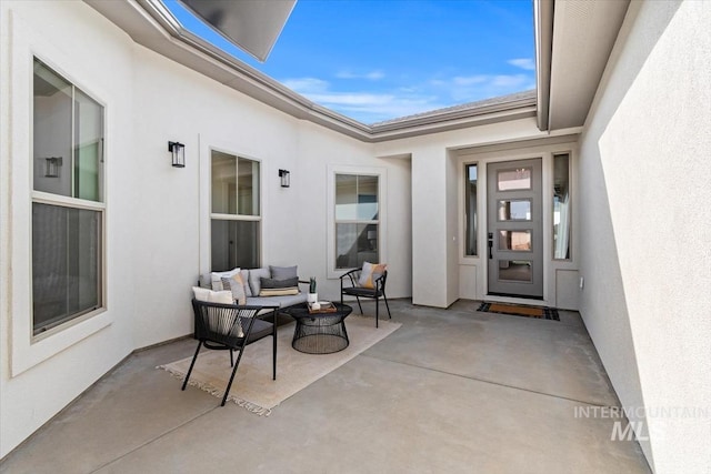 doorway to property with a patio area, an outdoor living space, and stucco siding