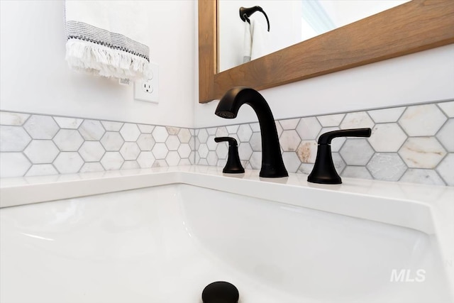 interior details featuring a sink and decorative backsplash