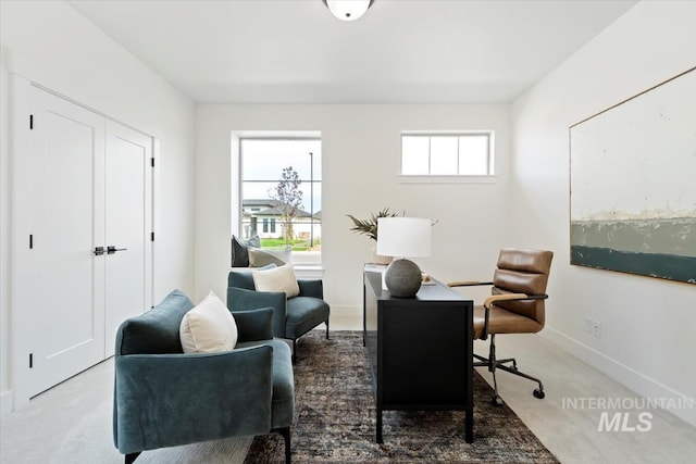 carpeted home office featuring baseboards