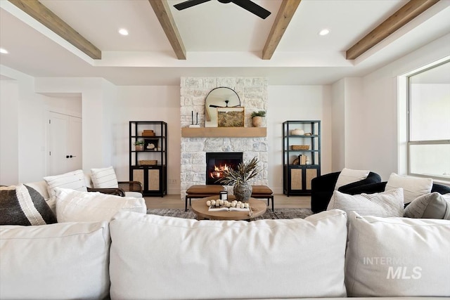 living room with a ceiling fan, beamed ceiling, light wood-style floors, a fireplace, and recessed lighting