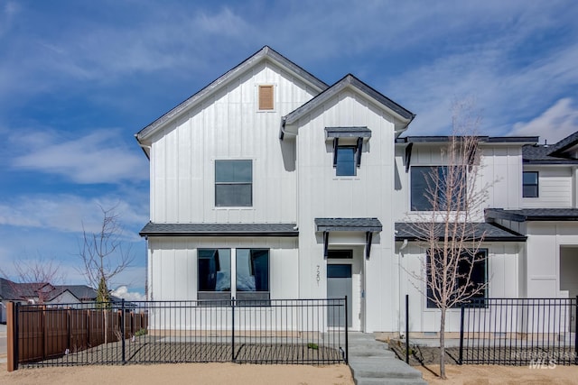 view of front facade featuring board and batten siding and fence private yard