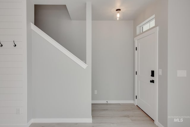 entryway with light wood-style flooring and baseboards