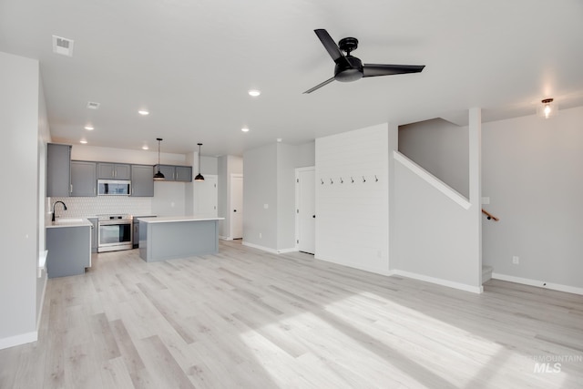 unfurnished living room with a sink, visible vents, ceiling fan, light wood-style floors, and recessed lighting