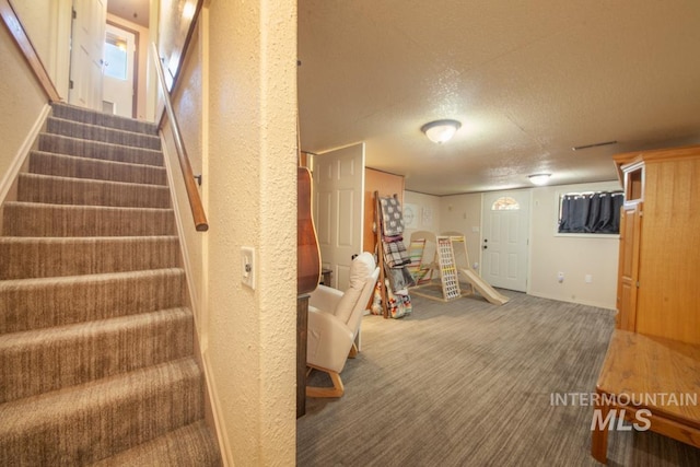 interior space with baseboards, a textured wall, a textured ceiling, and carpet floors