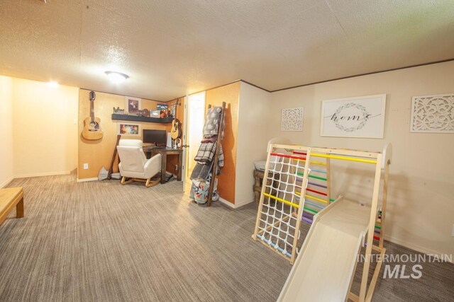 rec room featuring a textured ceiling, carpet flooring, and baseboards