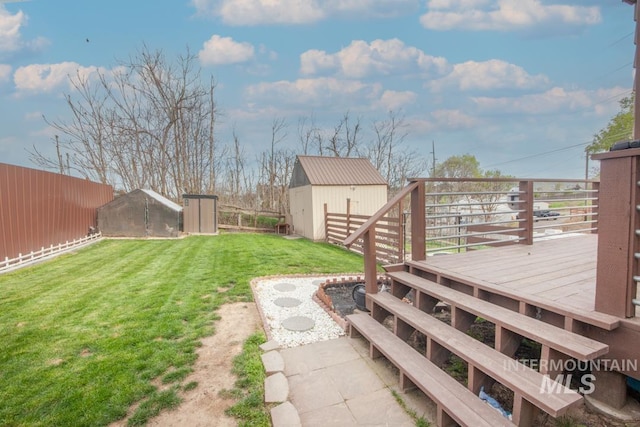 view of yard featuring a fenced backyard, an outbuilding, a deck, and a storage unit