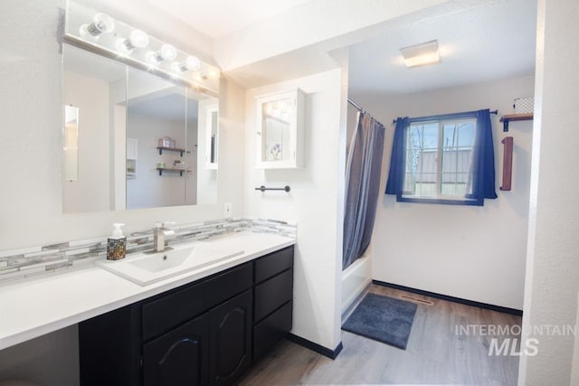 full bathroom featuring wood finished floors, visible vents, vanity, shower / tub combo with curtain, and baseboards