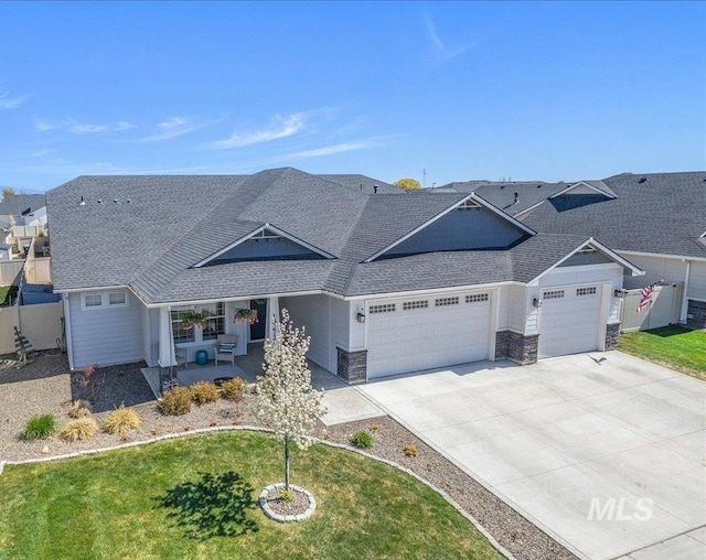 18272 N Wild Goose Ave, Nampa, ID 83687 - view of front of home with an attached garage, covered porch, a shingled roof, and a front lawn