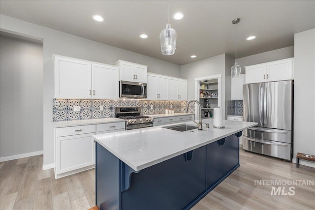 18272 N Wild Goose Ave, Nampa, ID 83687 - kitchen featuring stainless steel appliances, a sink, tasteful backsplash, light wood-style floors, and light stone counters
