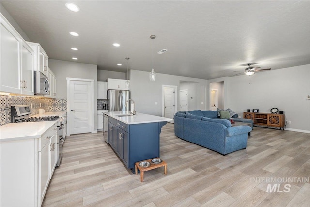 18272 N Wild Goose Ave, Nampa, ID 83687 - kitchen featuring appliances with stainless steel finishes, open floor plan, white cabinets, light wood-style floors, and recessed lighting