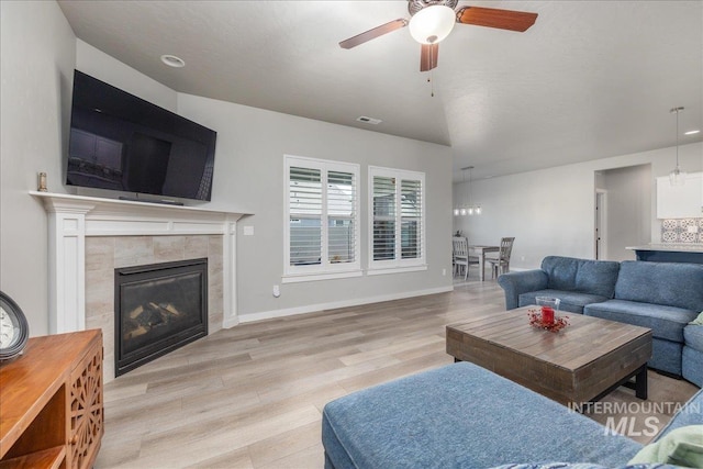 18272 N Wild Goose Ave, Nampa, ID 83687 - living area featuring a ceiling fan, light wood-style flooring, a tile fireplace, and baseboards