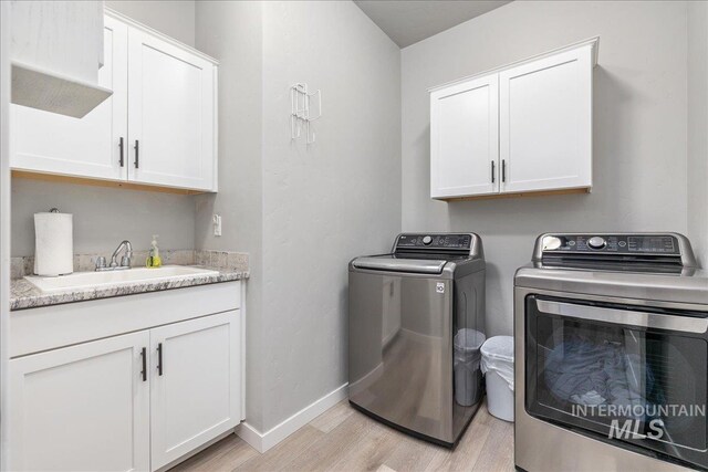 18272 N Wild Goose Ave, Nampa, ID 83687 - laundry room with washer and dryer, light wood-type flooring, cabinet space, and baseboards