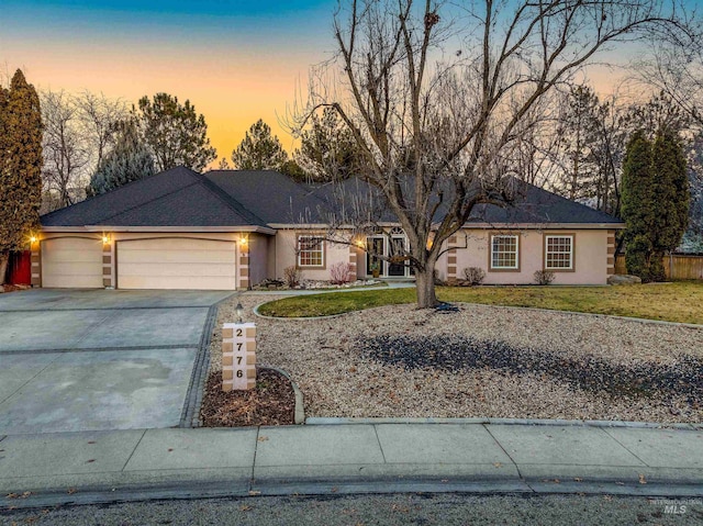 single story home featuring a garage and a yard