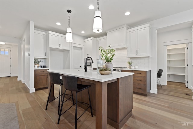 7766 W Daybreak Run Ct, Meridian, ID 83646 - kitchen with light countertops, backsplash, light wood-style floors, recessed lighting, and white cabinetry