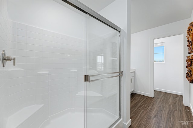 bathroom featuring hardwood / wood-style flooring, vanity, and a shower with shower door