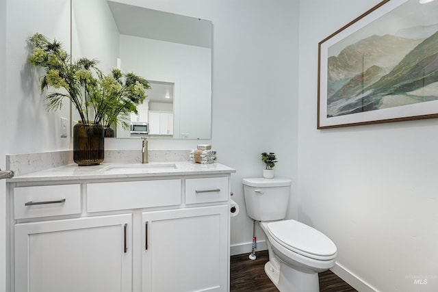 bathroom with vanity, hardwood / wood-style flooring, and toilet