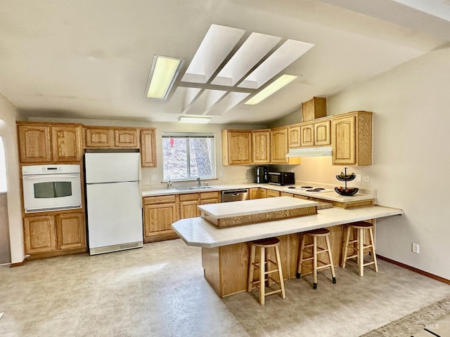 1089 Wallen Rd, Moscow, ID 83843 - kitchen featuring white appliances, a kitchen bar, light countertops, under cabinet range hood, and light flooring