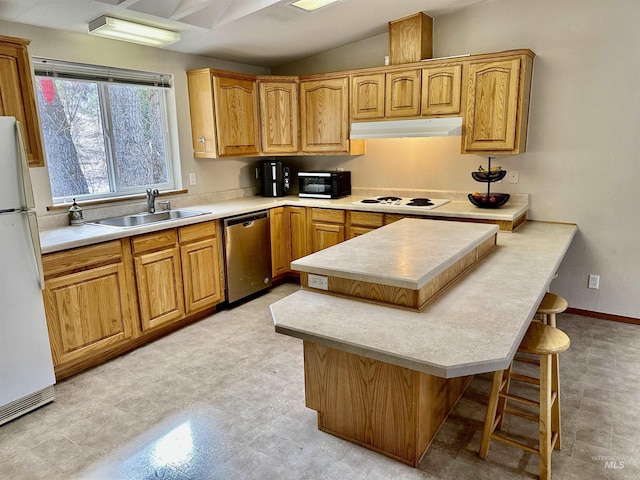 1089 Wallen Rd, Moscow, ID 83843 - kitchen with white appliances, a kitchen bar, under cabinet range hood, vaulted ceiling, and light countertops