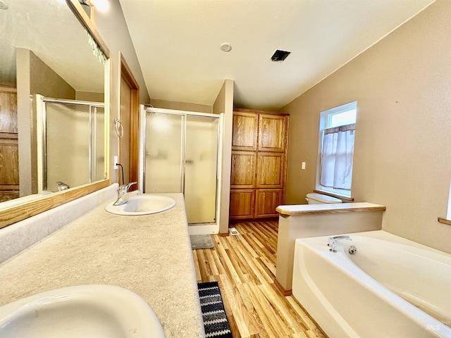 1089 Wallen Rd, Moscow, ID 83843 - bathroom with wood finished floors, a stall shower, a bath, vaulted ceiling, and double vanity