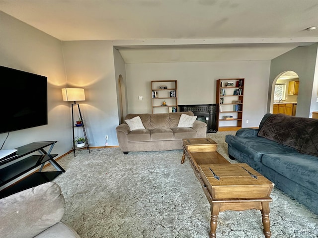 1089 Wallen Rd, Moscow, ID 83843 - living area featuring arched walkways, carpet flooring, beam ceiling, and a glass covered fireplace