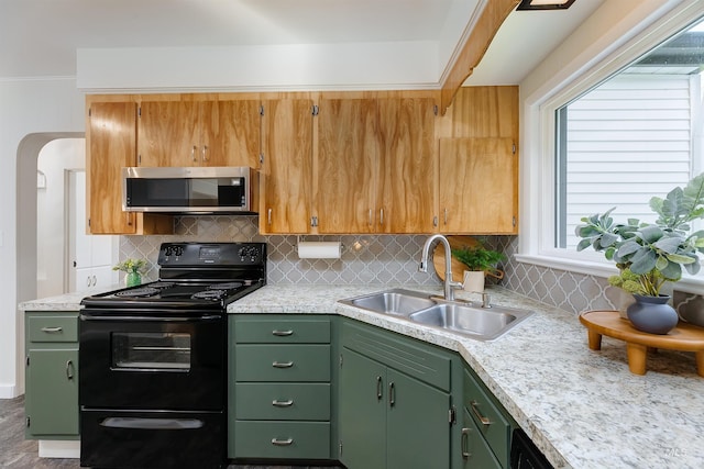 kitchen with electric range, green cabinets, sink, and tasteful backsplash