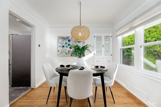 dining space with plenty of natural light and light hardwood / wood-style flooring