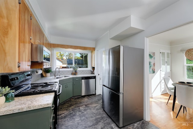 kitchen with tasteful backsplash, stainless steel appliances, green cabinetry, and sink