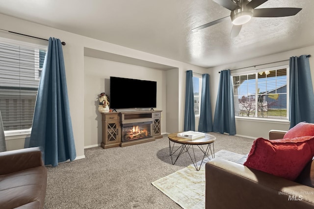 living room with ceiling fan, a textured ceiling, and carpet