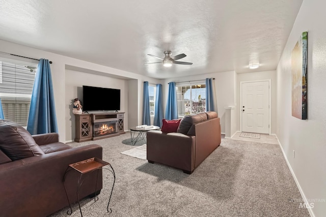 living room featuring ceiling fan, light carpet, and a textured ceiling