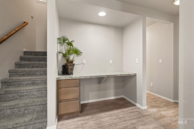 interior space featuring built in desk and light hardwood / wood-style floors