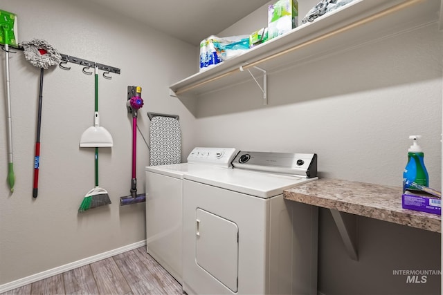 clothes washing area featuring washing machine and dryer and light wood-type flooring